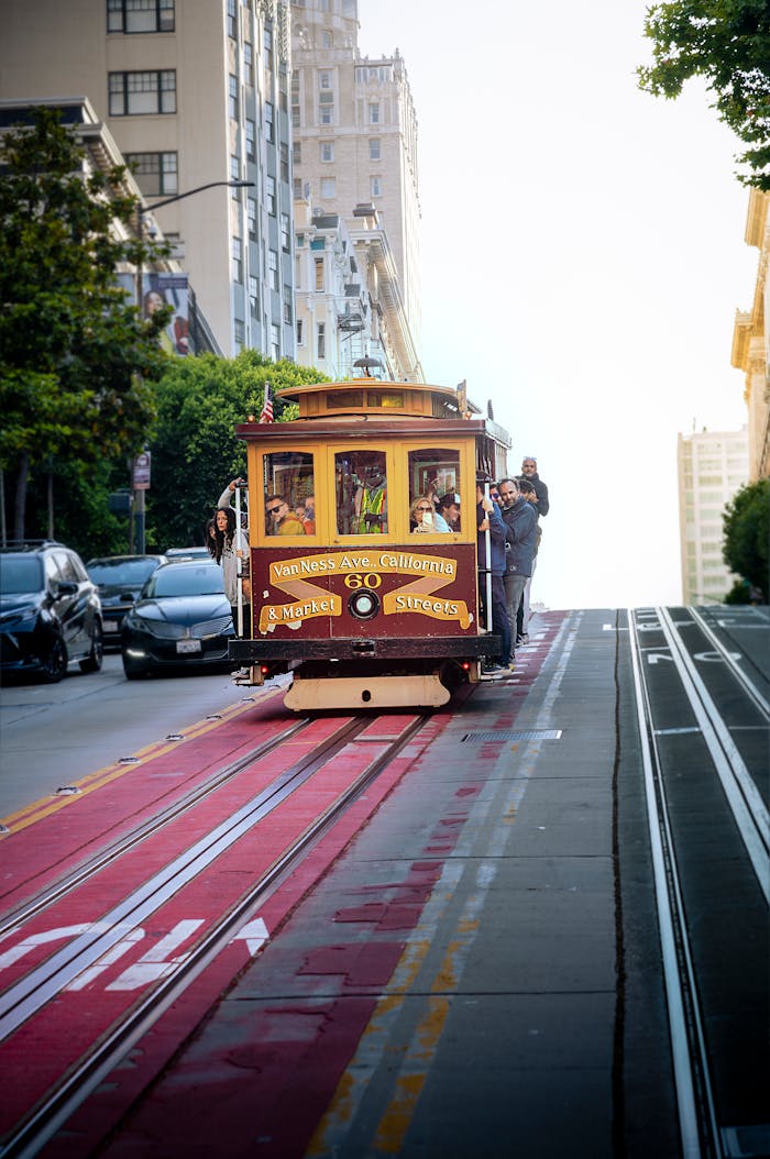 how-it-works Classic San Francisco cable car rides uphill on a sunlit street, capturing urban charm.